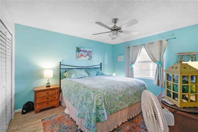 bedroom featuring a textured ceiling, hardwood / wood-style floors, and ceiling fan