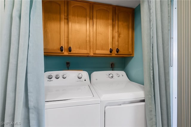 laundry area featuring cabinets and washing machine and clothes dryer