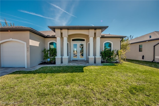 view of front of property featuring a front yard, french doors, and a garage