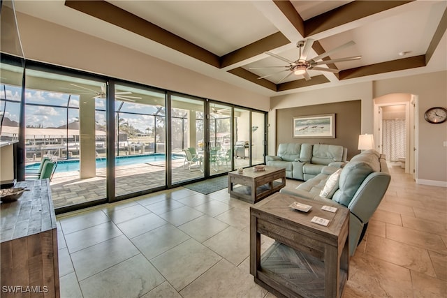 living room featuring beam ceiling, ceiling fan, coffered ceiling, and a healthy amount of sunlight