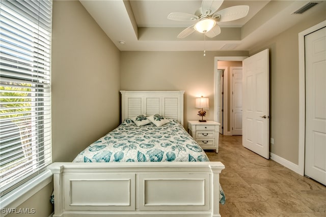 bedroom featuring ceiling fan and a tray ceiling