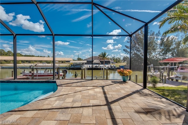 view of pool featuring a boat dock, glass enclosure, a water view, and a patio area