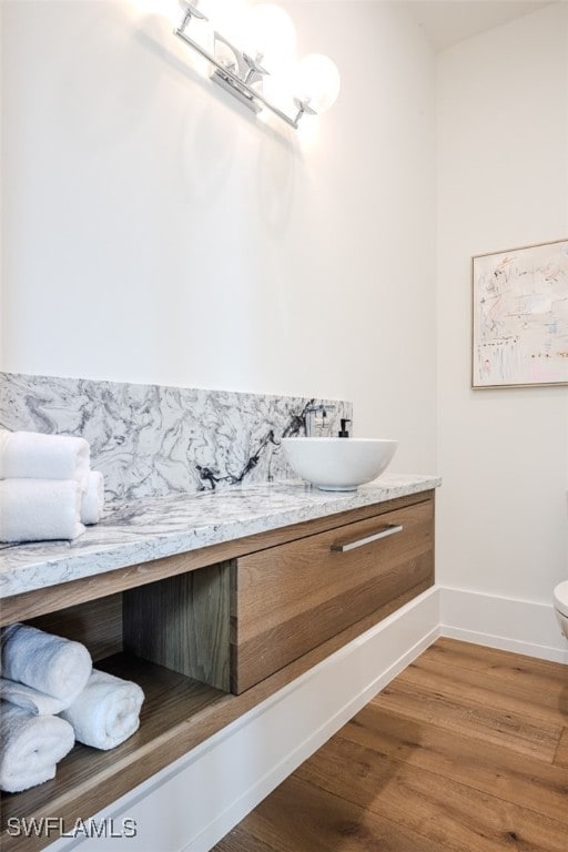 bathroom featuring wood-type flooring, vanity, and toilet