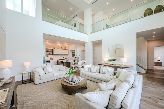 living room with a high ceiling and light hardwood / wood-style flooring