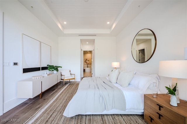 bedroom featuring a tray ceiling and dark hardwood / wood-style floors