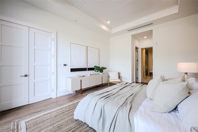 bedroom featuring a raised ceiling, wood ceiling, and hardwood / wood-style floors