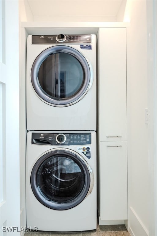 clothes washing area with stacked washer / dryer