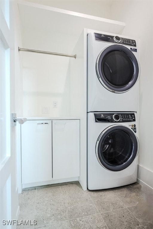 washroom with stacked washing maching and dryer