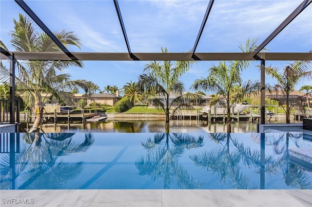 view of swimming pool with a water view and a lanai