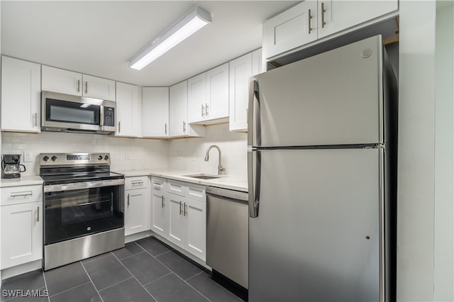 kitchen featuring stainless steel appliances, white cabinets, sink, and tasteful backsplash