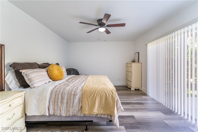 bedroom featuring multiple windows, hardwood / wood-style flooring, and ceiling fan