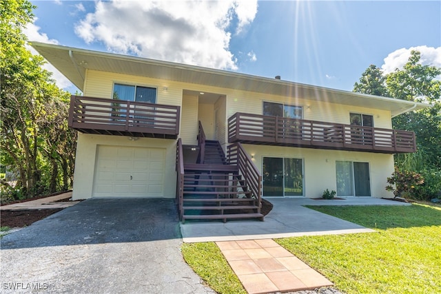 view of front of property with a garage, a front yard, and a balcony