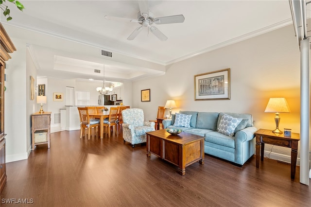 living room featuring ceiling fan with notable chandelier, ornamental molding, dark hardwood / wood-style floors, and a tray ceiling