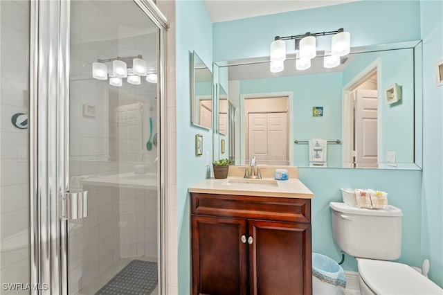 bathroom featuring an enclosed shower, vanity, and toilet