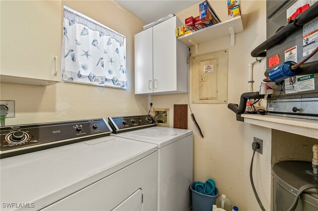 laundry area featuring washer and clothes dryer, cabinets, and electric panel