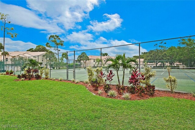 view of tennis court with a lawn