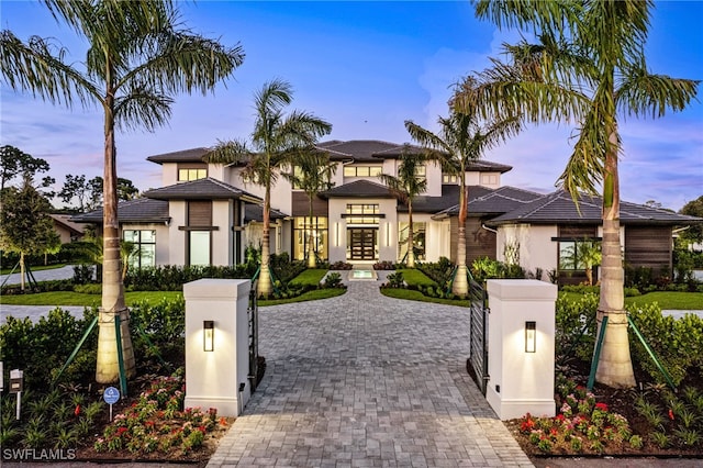 796 Cassena Rd, Naples, FL 34108 - view of front facade featuring stucco siding, french doors, a gate, and decorative driveway