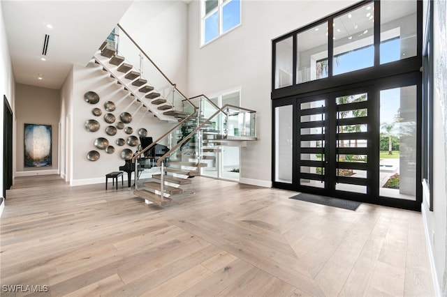 foyer entrance with parquet flooring, french doors, and a high ceiling