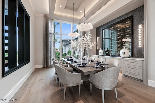 dining room featuring light hardwood / wood-style floors and a tray ceiling