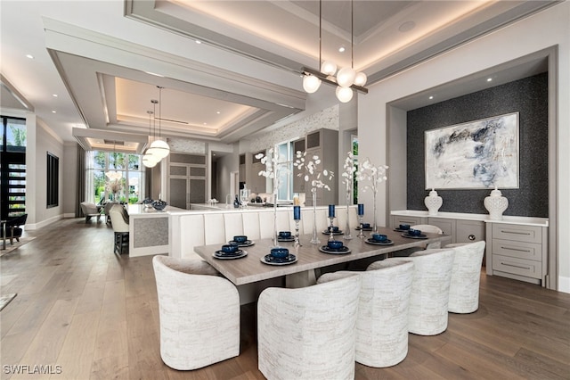 dining area with a raised ceiling and hardwood / wood-style flooring