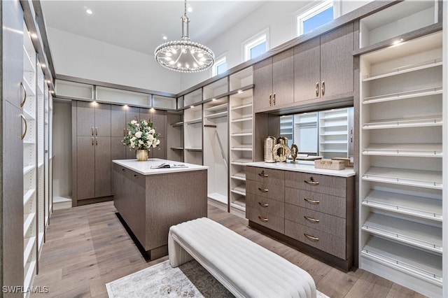 spacious closet featuring a chandelier and light hardwood / wood-style flooring