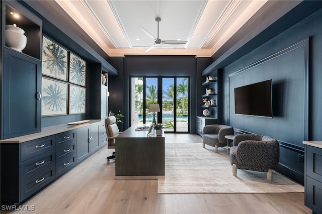 office area featuring ceiling fan, light hardwood / wood-style floors, ornamental molding, and a tray ceiling