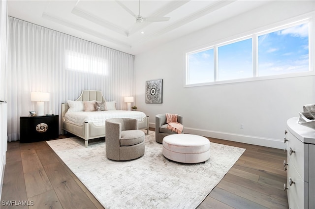 bedroom with ornamental molding, a tray ceiling, ceiling fan, and hardwood / wood-style flooring