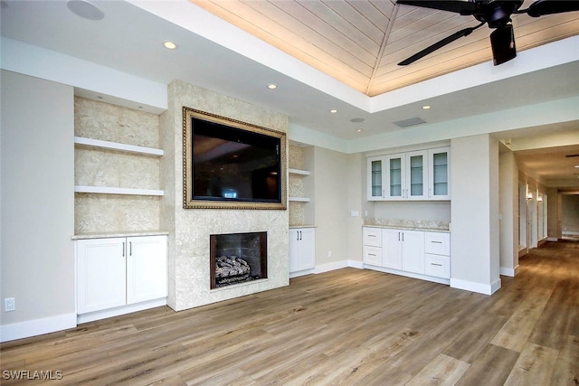 unfurnished living room featuring light hardwood / wood-style floors, a fireplace, and ceiling fan