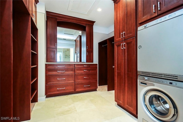 laundry area with stacked washer / drying machine and cabinets