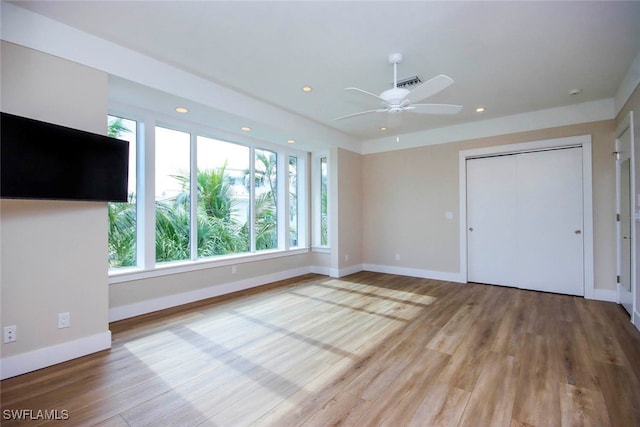 unfurnished bedroom with ceiling fan, light hardwood / wood-style flooring, and a closet