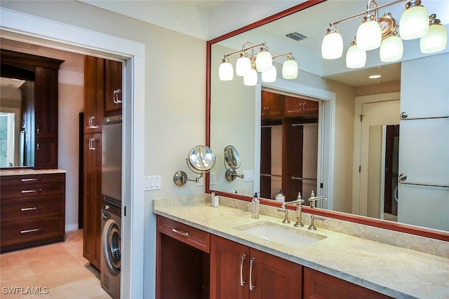 bathroom with washer / clothes dryer, vanity, and tile patterned floors