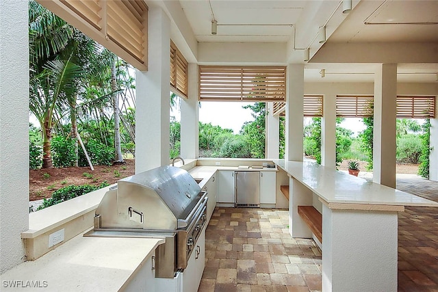 view of patio / terrace featuring grilling area, an outdoor kitchen, and exterior bar