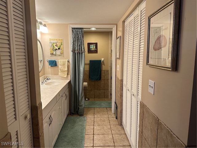 bathroom featuring tile walls, tile patterned flooring, and vanity