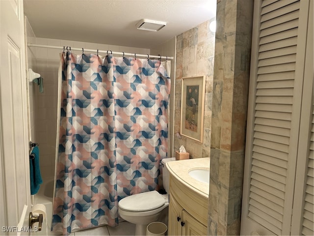 bathroom with vanity, tile walls, toilet, and a textured ceiling