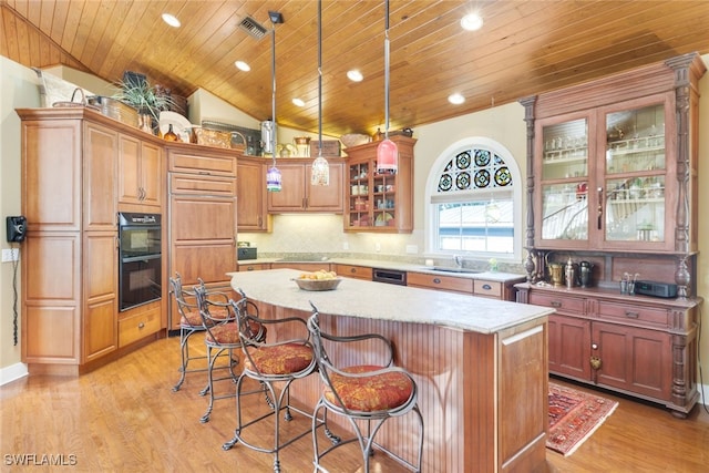 kitchen featuring a center island, vaulted ceiling, black appliances, decorative light fixtures, and wooden ceiling