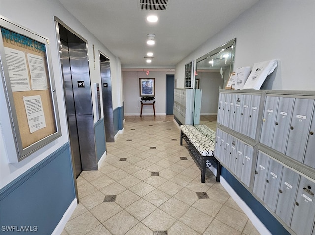 hallway featuring light tile patterned floors, a mail area, and elevator