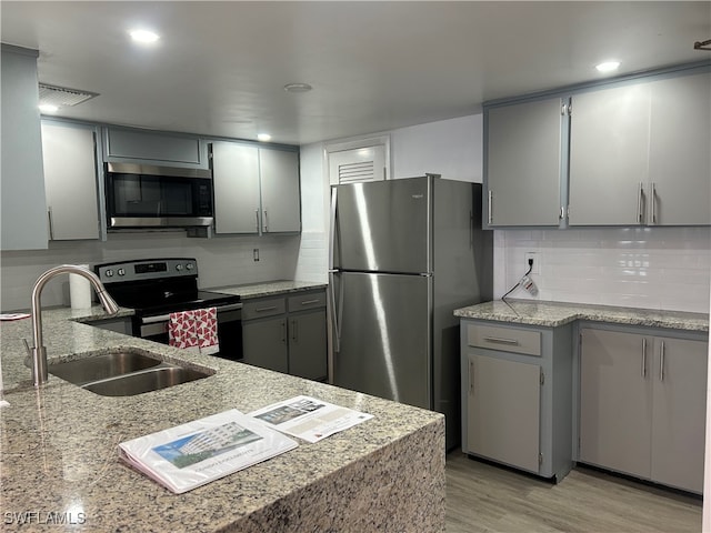 kitchen featuring gray cabinets, light wood-type flooring, and appliances with stainless steel finishes