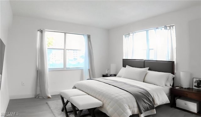 bedroom with multiple windows and hardwood / wood-style flooring