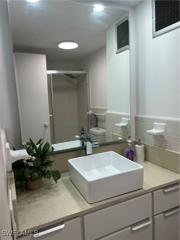 bathroom with walk in shower, vanity, and toilet