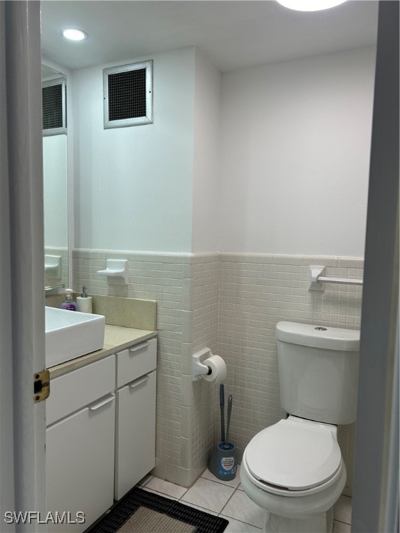 bathroom featuring vanity, tile walls, tile patterned flooring, and toilet