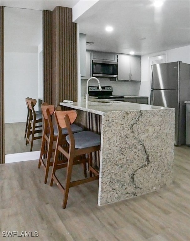 kitchen with appliances with stainless steel finishes and light hardwood / wood-style flooring