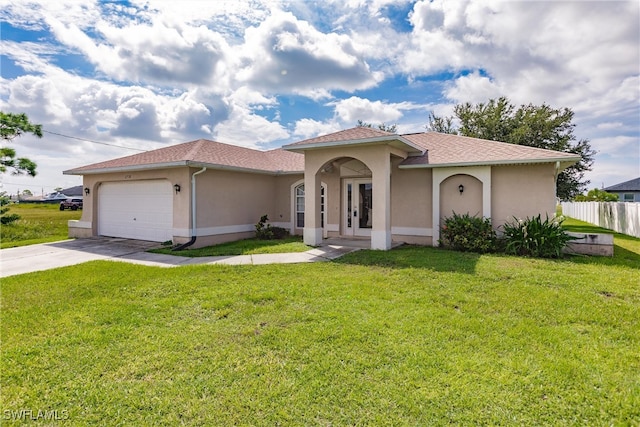 mediterranean / spanish home featuring a garage and a front lawn