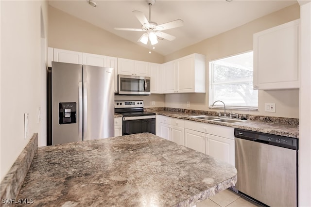 kitchen featuring ceiling fan, lofted ceiling, sink, white cabinetry, and stainless steel appliances