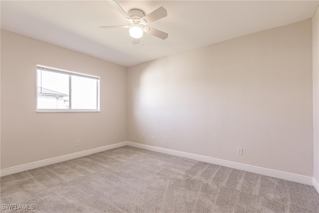 spare room with ceiling fan and light colored carpet