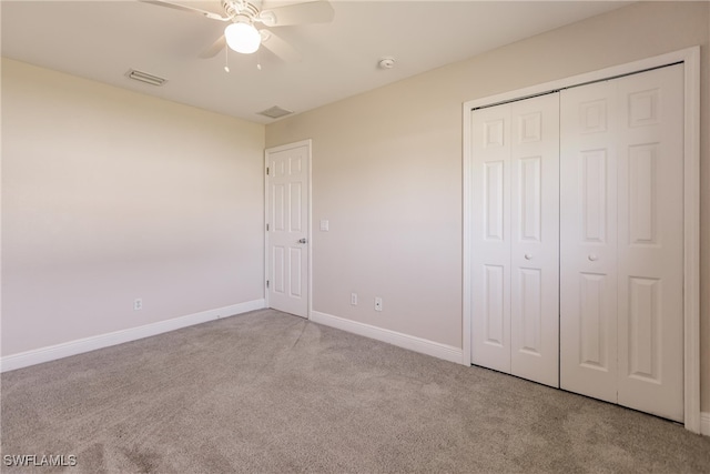 unfurnished bedroom featuring ceiling fan, light colored carpet, and a closet