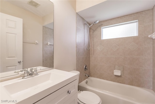 full bathroom featuring tiled shower / bath combo, vanity, and toilet