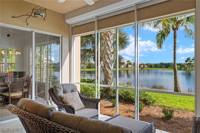 sunroom / solarium with a water view and ceiling fan