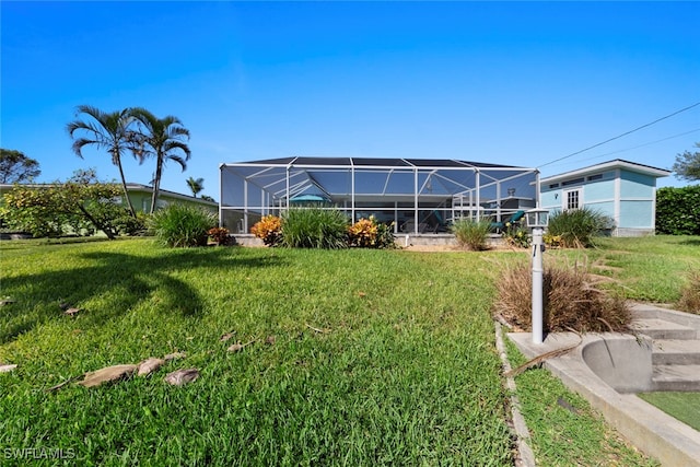 rear view of house featuring a lanai and a lawn