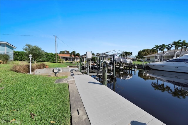 view of dock with a water view and a lawn