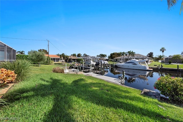 view of dock with a water view and a lawn